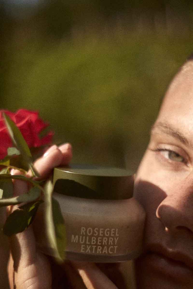 picture of a woman holding fields of yarrow's rosegel and mulberry extract face mask