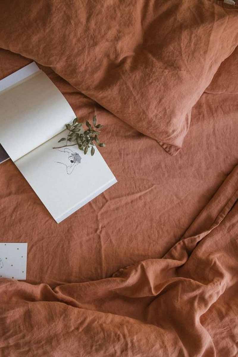 image of a bed with pink sheets and book on it